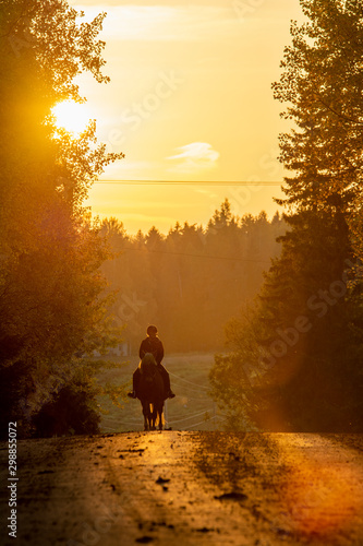 Woman horseback riding in sunset