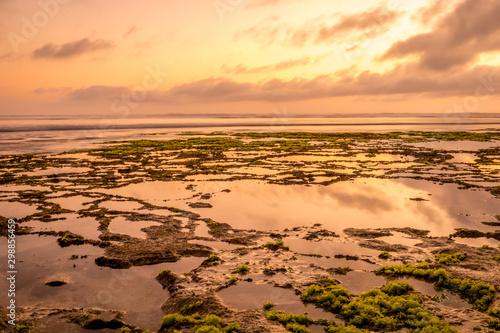 Seascape. Golden hour of sunset at the beach. Ocean low tide. Horizontal background banner. Nyang Nyang beach, Bali, Indonesia.