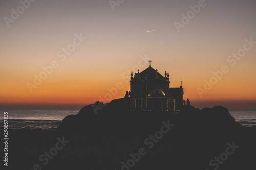 Capela do Senhor da Pedra in Porto, Portugal under the sunset by the sea