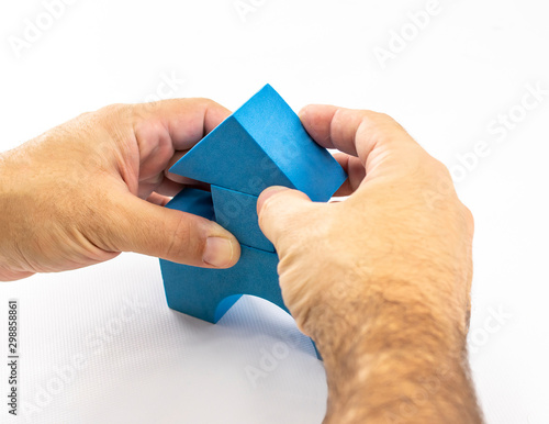 Man's hands perform a construction with constructive elements of a children's toy