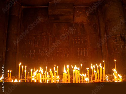 Candles shining brightly in a dark chapel of an Orthodox church Fotobehang