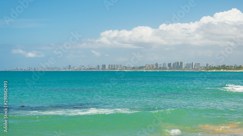 A view of the beach in Itapua, Salvador's cityscape in the background - Bahia, Brazil photo