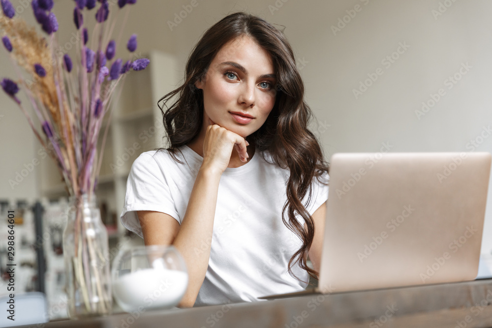 Image of nice caucasian woman using laptop while sitting Image of nice caucasian woman using laptop while sitting