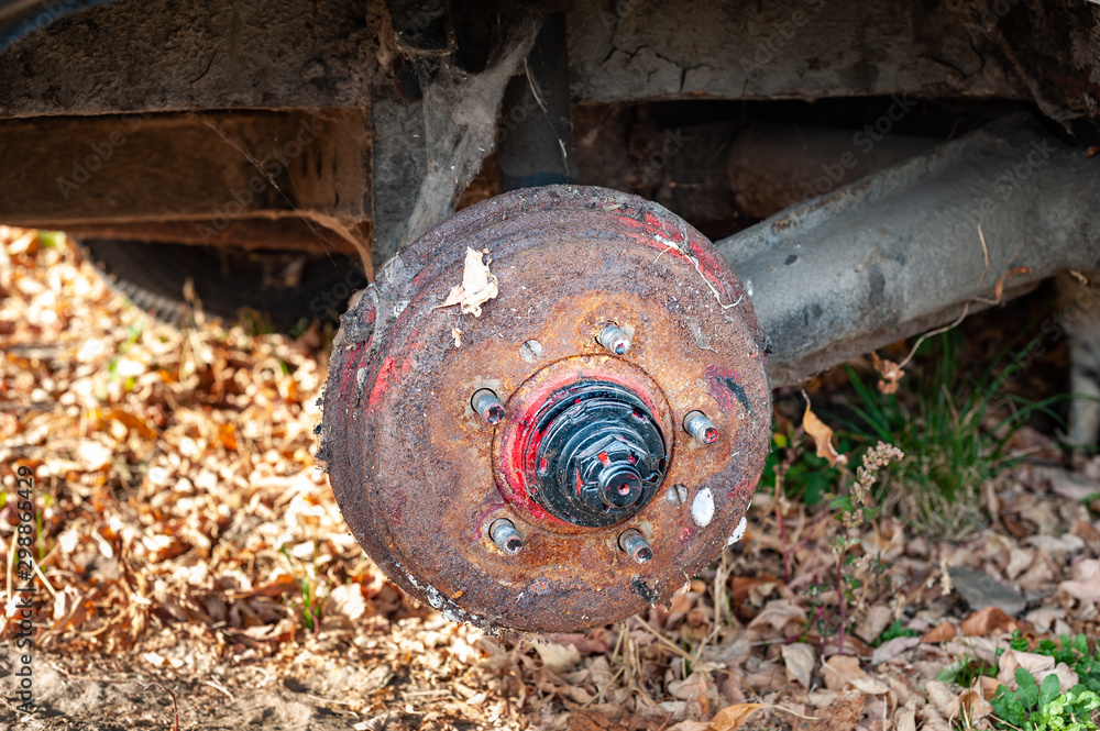 Old rusty dirty brake drum and suspension details of a broken abandoned car on the street. Old rusty dirty brake drum and suspension details of a broken abandoned car on the street.