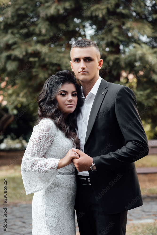 Obraz premium Couple in love - beginning of a love story. A man and a girl in the park. Beautiful pre-wedding photo of the bride and groom. Young couple show love for each other, a holiday