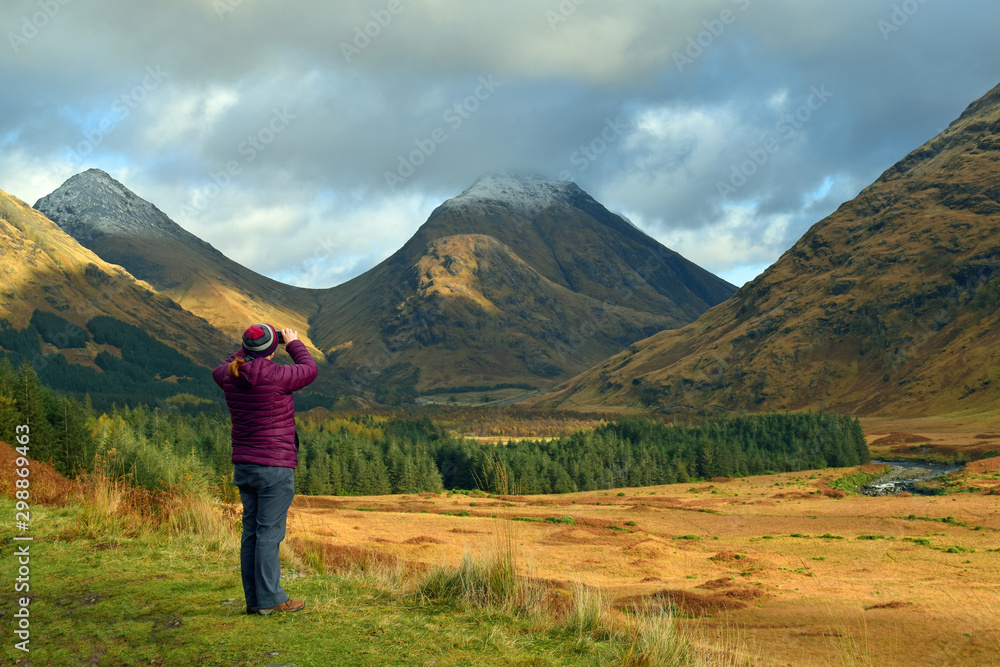 Woman (not recognisable) taking cellphone photo in Glen Etive Scottish Highlands - obrazy, fototapety, plakaty 