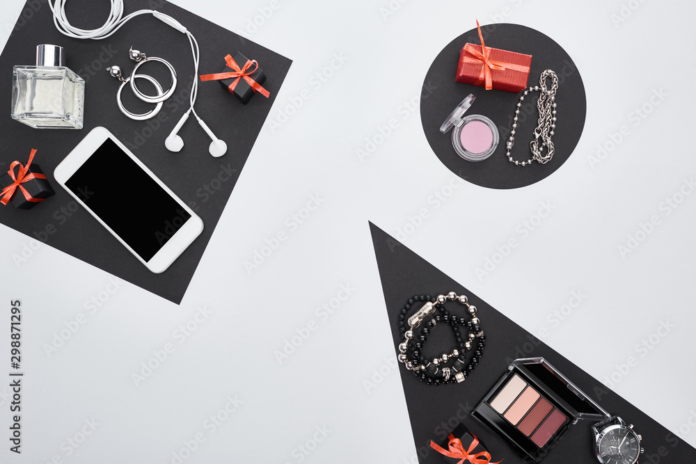 Obraz premium top view of gadget, gift boxes, perfume, bracelets, decorative cosmetics, earrings, earphones