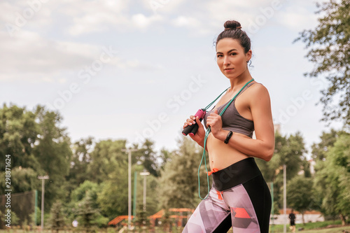 Fototapeta Naklejka Na Ścianę i Meble -  Slim fit caucasian brunette woman outdoor exercising in sport outfit. Summer morning