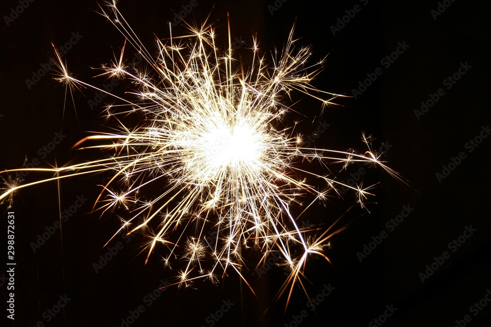 Closeup view of bright burning sparkler on a black background