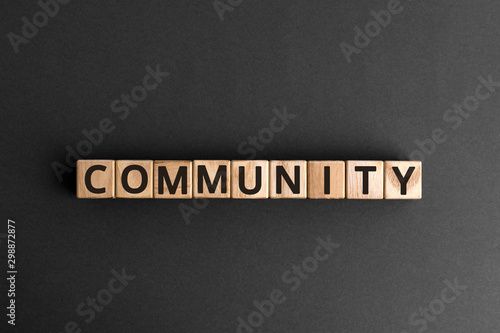 Community - word from wooden blocks with letters, a group of people who have similar interests community concept, top view on grey background