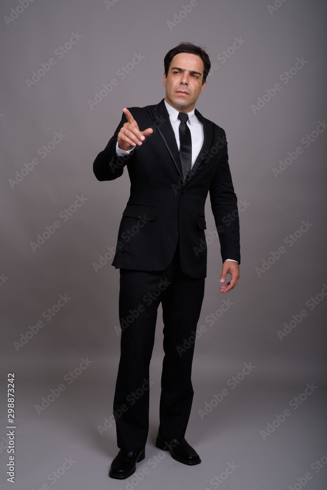 Full body shot of handsome Persian businessman in suit Full body shot of handsome Persian businessman in suit