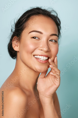 Beauty face. Smiling asian woman touching healthy skin portrait. Beautiful ha...