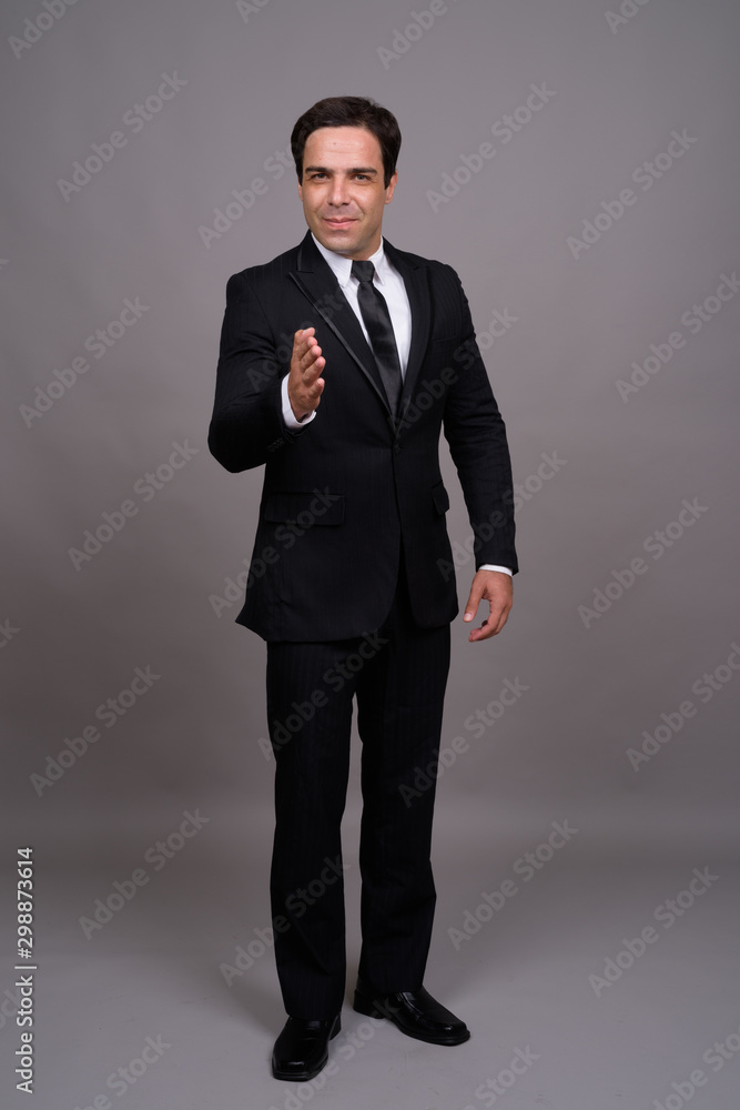 Full body shot of handsome Persian businessman in suit Full body shot of handsome Persian businessman in suit