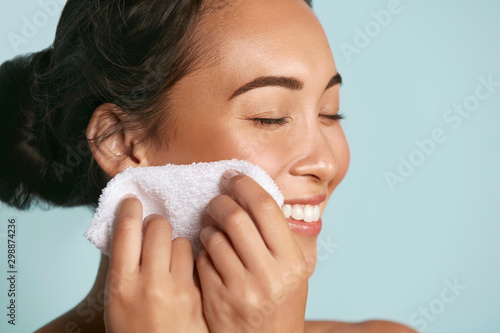 Woman cleaning facial skin with towel after washing face portrait. Beautiful ...