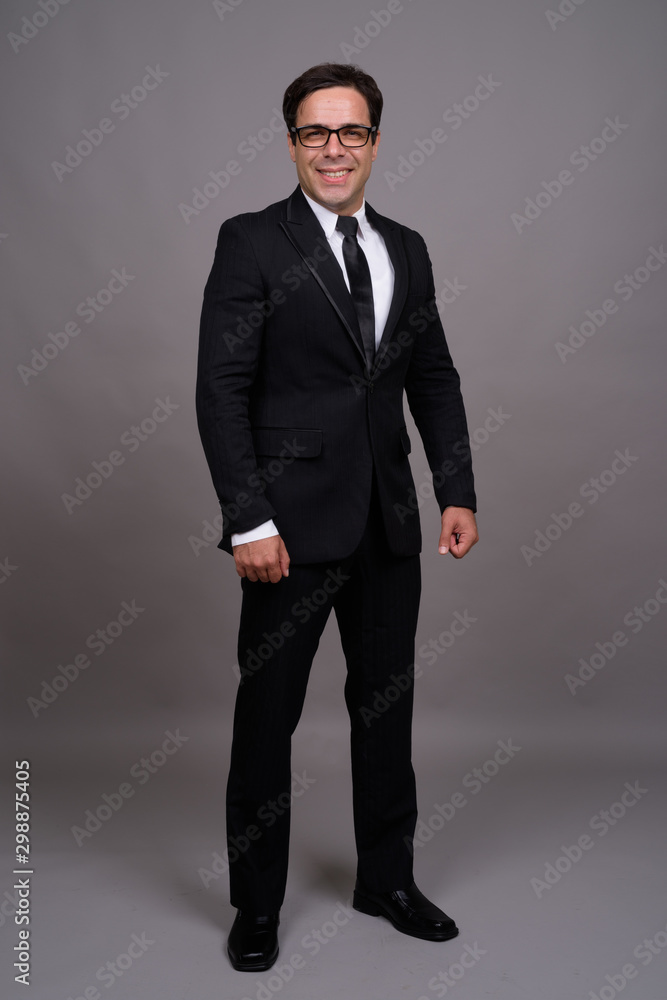 Full body shot of handsome Persian businessman in suit