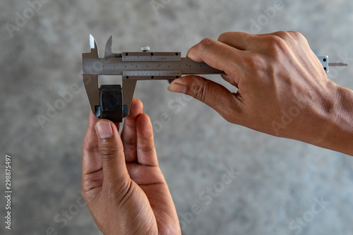 Foto Using Vernier caliper to measure the dimensions of the nut.