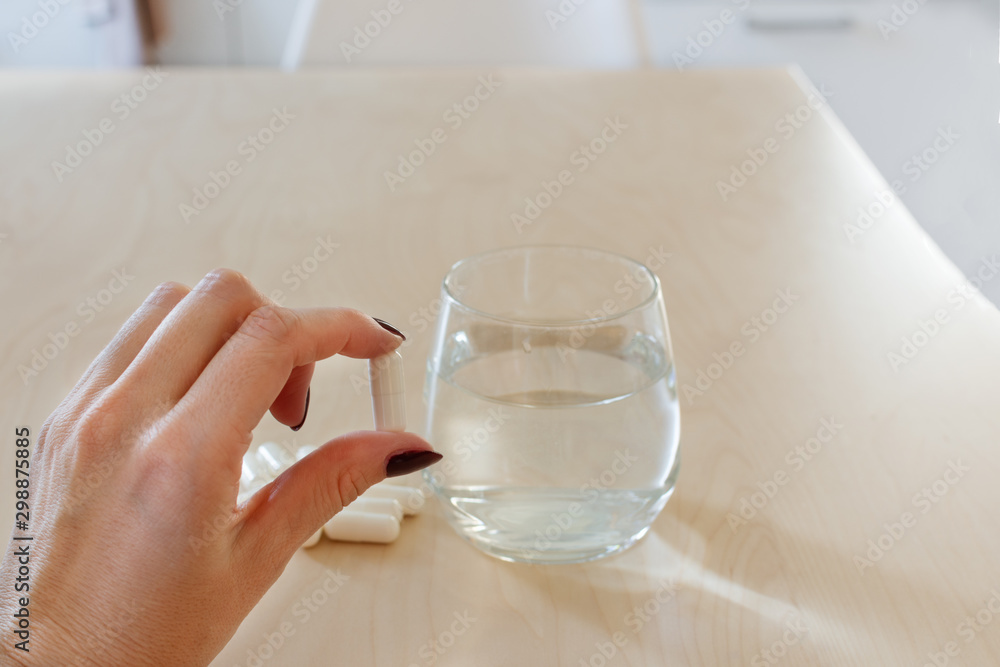 Pills and glass of water on wooden table. Pills and glass of water on wooden table.