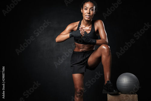Image of happy african american woman in sportswear and hand wraps