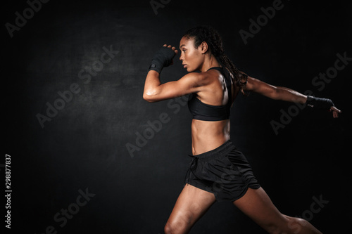 Image of young african american woman in sportswear and hand wraps running