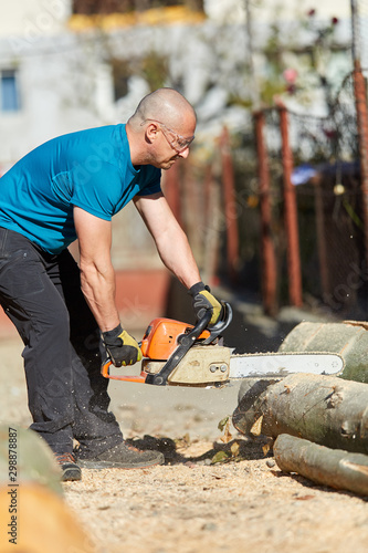 Strong farmer with chainsaw