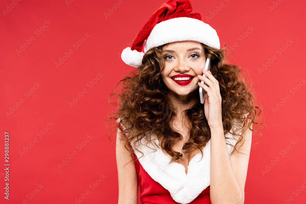 beautiful happy woman in santa costume talking on smartphone, isolated on red beautiful happy woman in santa costume talking on smartphone, isolated on red