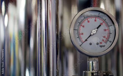 View of analog meter ,steel pipes and industrial process equipment background                  