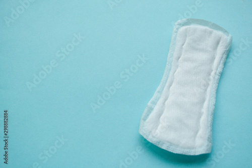 Clean white daily, menstrual pad for hygiene or blood period. Sanitary soft padding, hygiene protection. Conception of Woman's health, gynecological menstruation cycle. Blue background