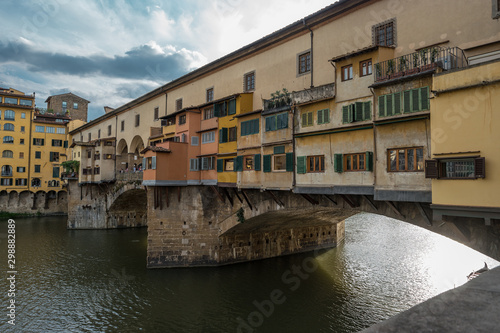 Side view of medieval stone bridge Ponte Vecchio over the Arno River in Florence, Tuscany, Italy.