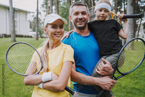 Happy family with tennis rackets standing on the street © Yakobchuk Olena