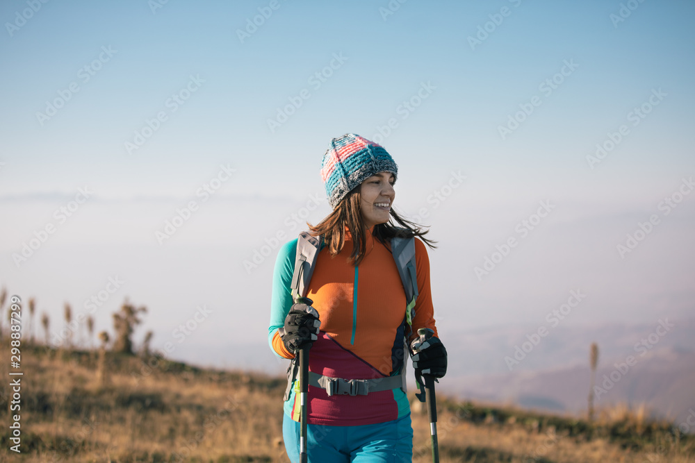 Young woman hiker standing at the mountaintop - obrazy, fototapety, plakaty 