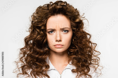 attractive upset curly girl in white t-shirt, isolated on white