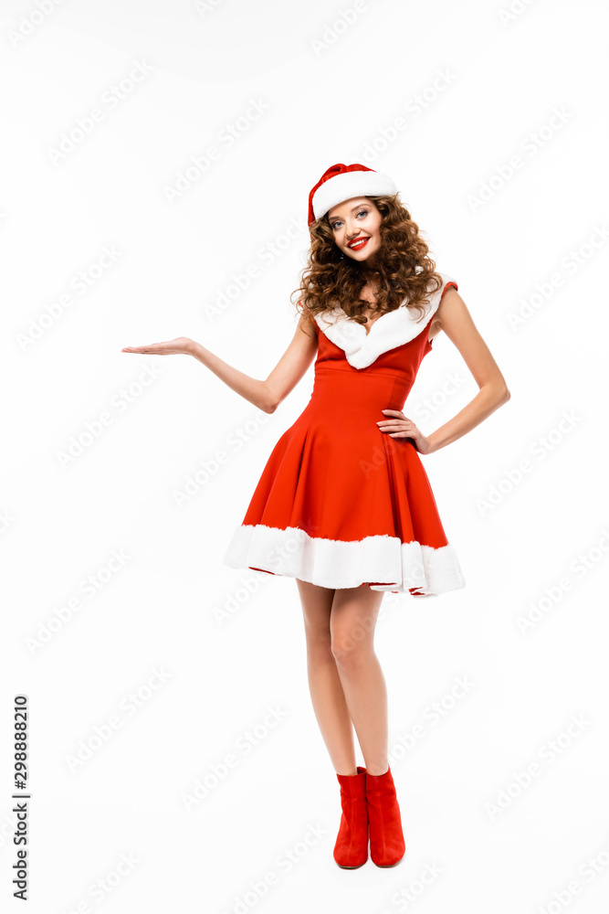 smiling girl posing in santa costume and presenting something, isolated on white smiling girl posing in santa costume and presenting something, isolated on white
