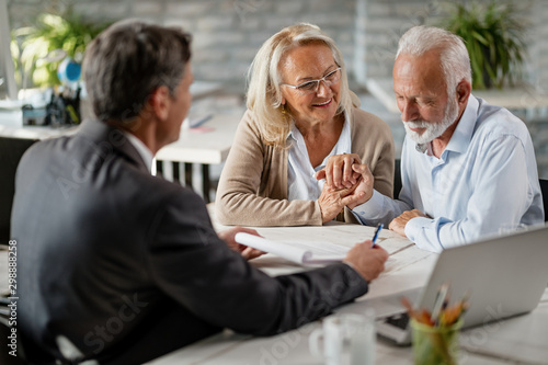 Cuadro en lienzo Happy senior couple about to sign a contract during a meeting with their insurance agent