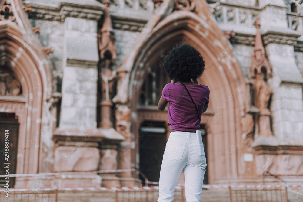 Slim and fit lady looking at ancient church in city