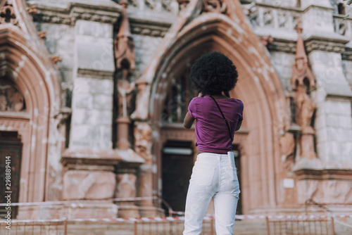 Slim and fit lady looking at ancient church in city