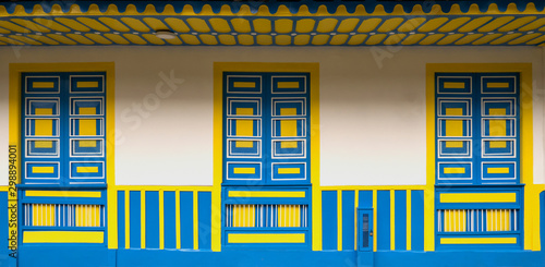 Traditional architecture of the coffee region, with three windows and base in blue and yellow colors, in Filandia Colombia,