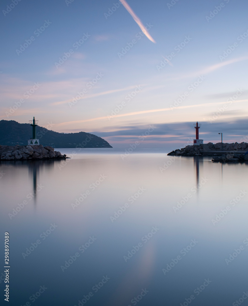 Sunrise Cala Bona Harbour Majorca with silky smooth flat sea and beautiful reflections in the water.