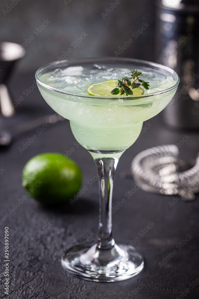 margarita cocktail with lime in a glass on dark background margarita cocktail with lime in a glass on dark background