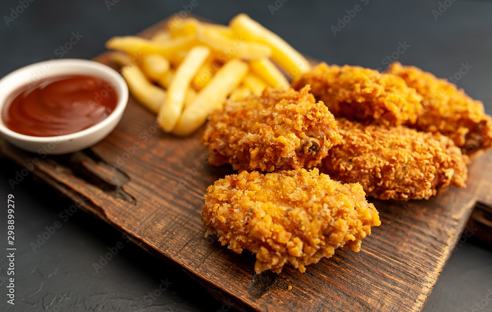 fried chicken with french fries and food nuggets - on stone background fried chicken with french fries and food nuggets - on stone background