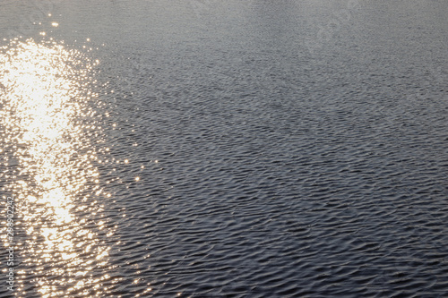 Water surface with reflection of light rays. The concept of tourism, tranquility and relaxation. Copy space for text