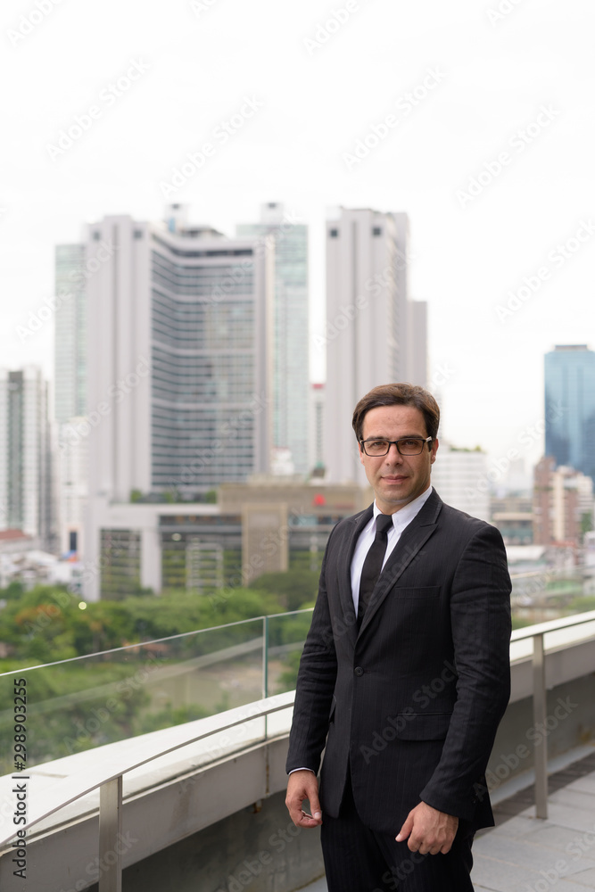 Handsome Persian businessman against view of the city Handsome Persian businessman against view of the city