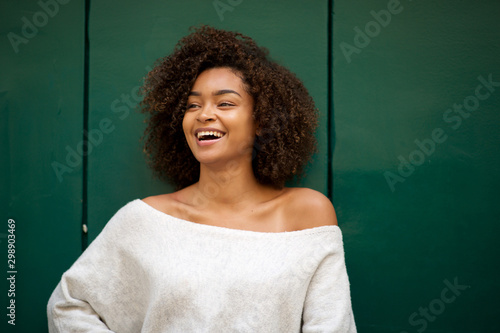 laughing young african american woman against green background photo