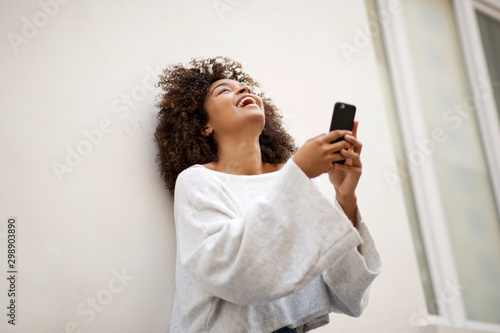 young african american woman laughing with mobile phone