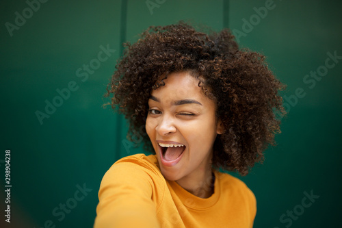 happy african american young woman taking selfie with winking eye photo