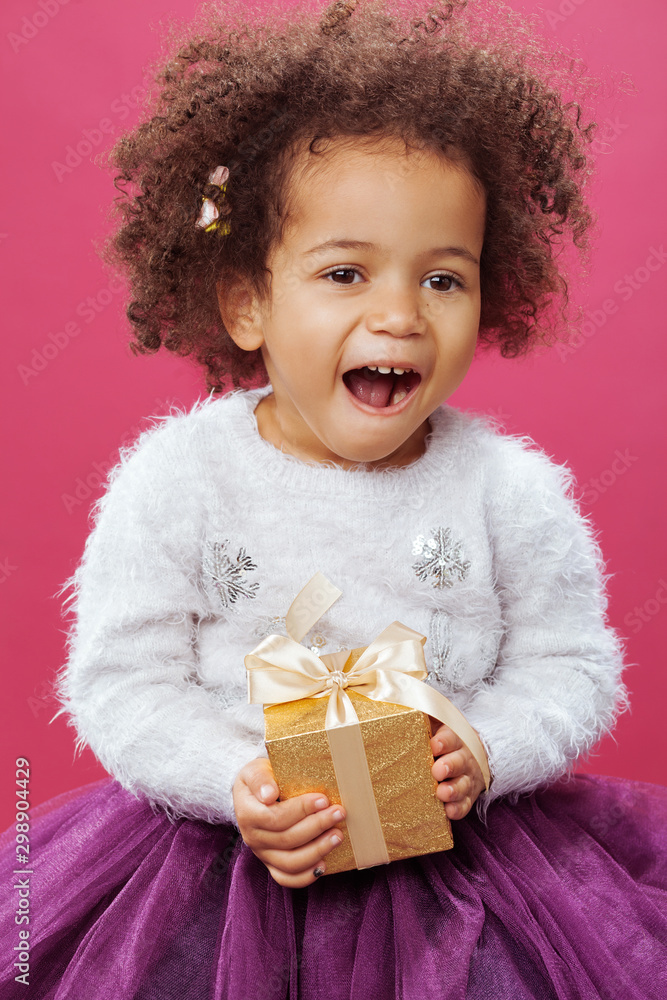 Cute little girl holding a shiny gift box Cute little girl holding a shiny gift box