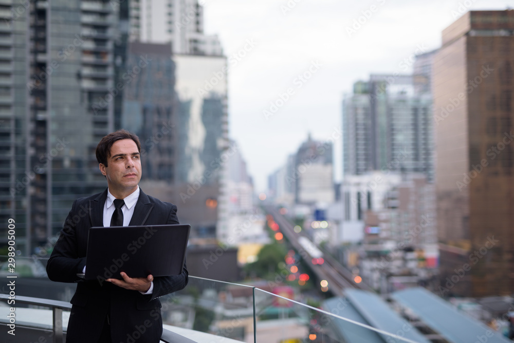 Handsome Persian businessman against view of the city Handsome Persian businessman against view of the city