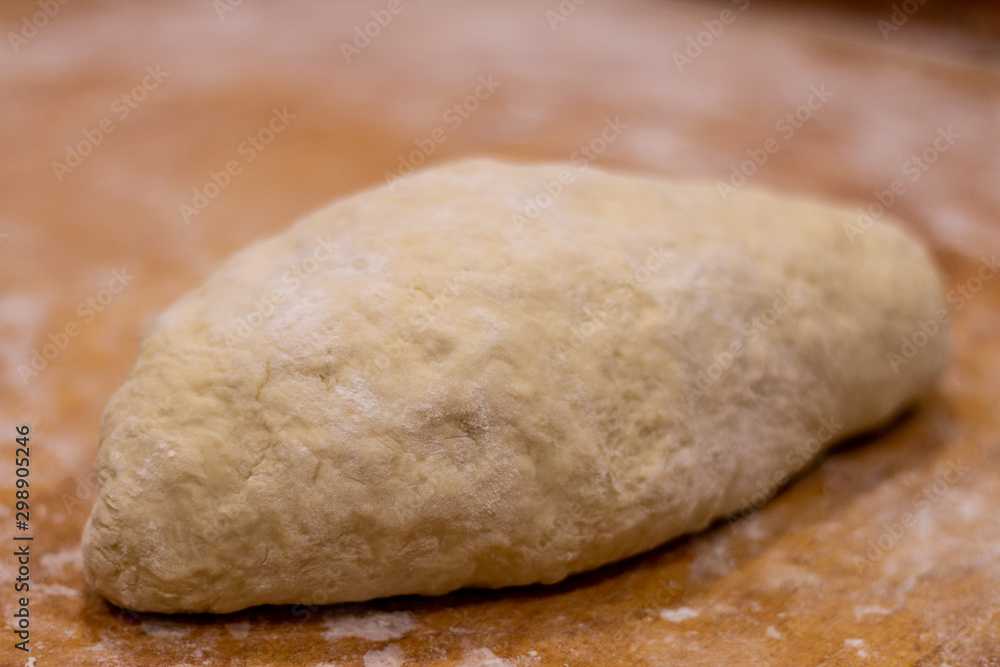 Fresh homemade dough for making white bread on a wooden board close-up. Home cooking and baking. Fresh homemade dough for making white bread on a wooden board close-up. Home cooking and baking.