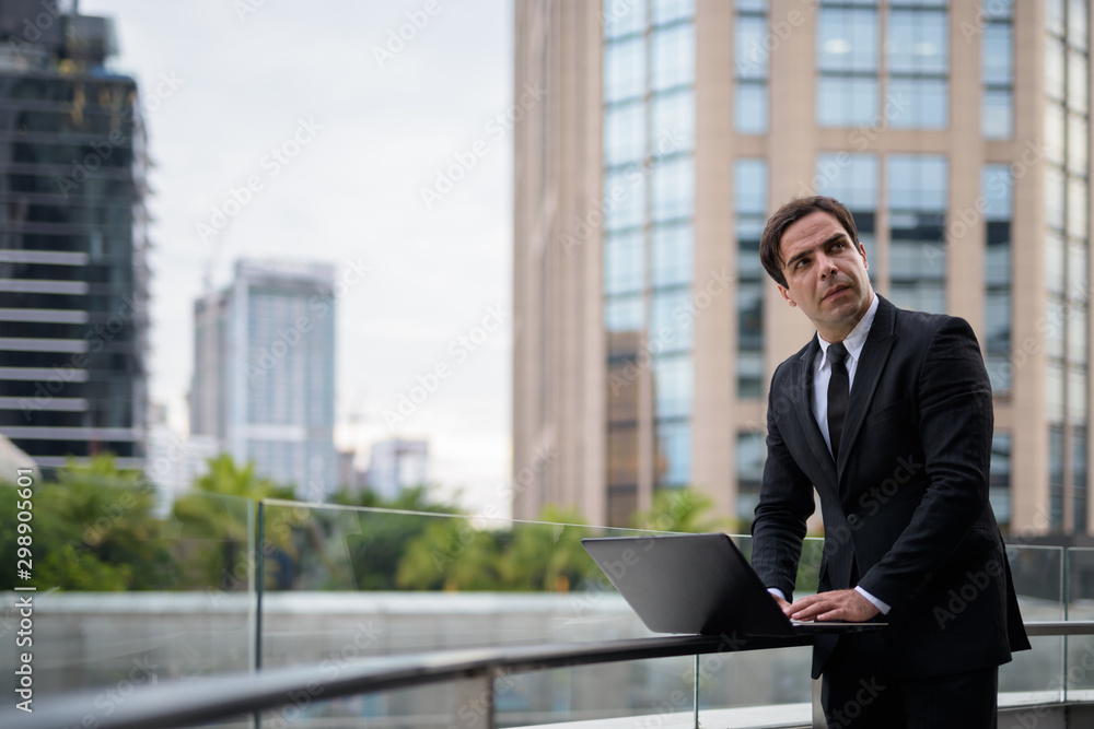 Handsome Persian businessman against view of the city Handsome Persian businessman against view of the city