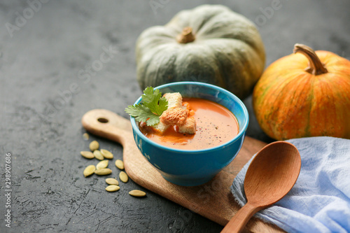  Vegetarian autumn pumpkin cream soup with seeds. Seasonal autumn food - pumpkin soup with thyme. Pumpkin soup with herbs, cream, breadcrumbs and parmesan, served in a bowl, top view. Place for text
