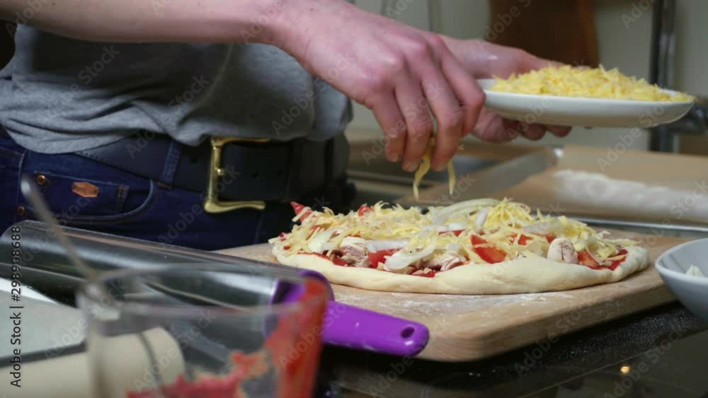 Young woman preparing pizza in kitchen Young woman preparing pizza in kitchen